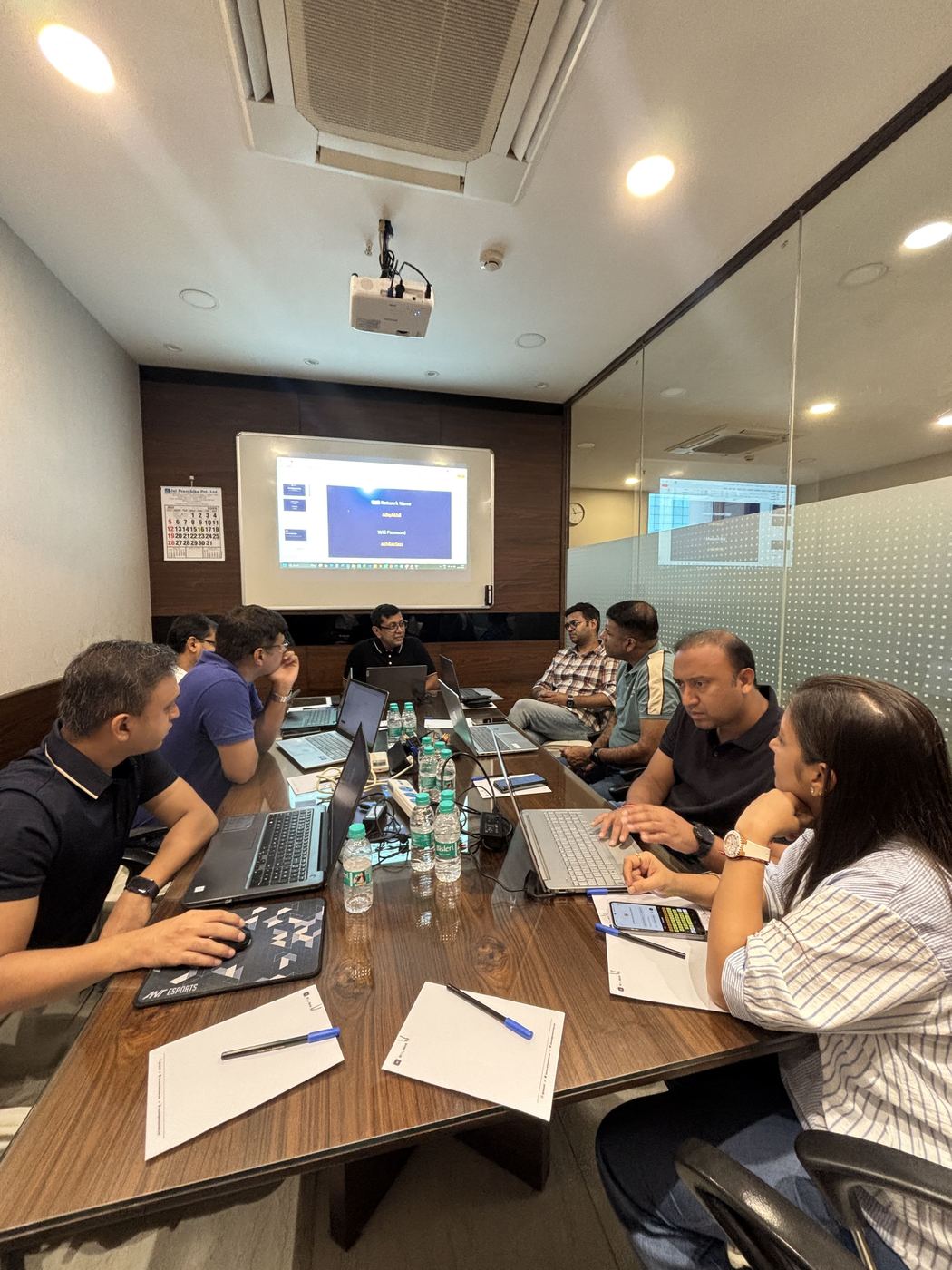 Participants working on their laptops around the table during an AI Starter Session